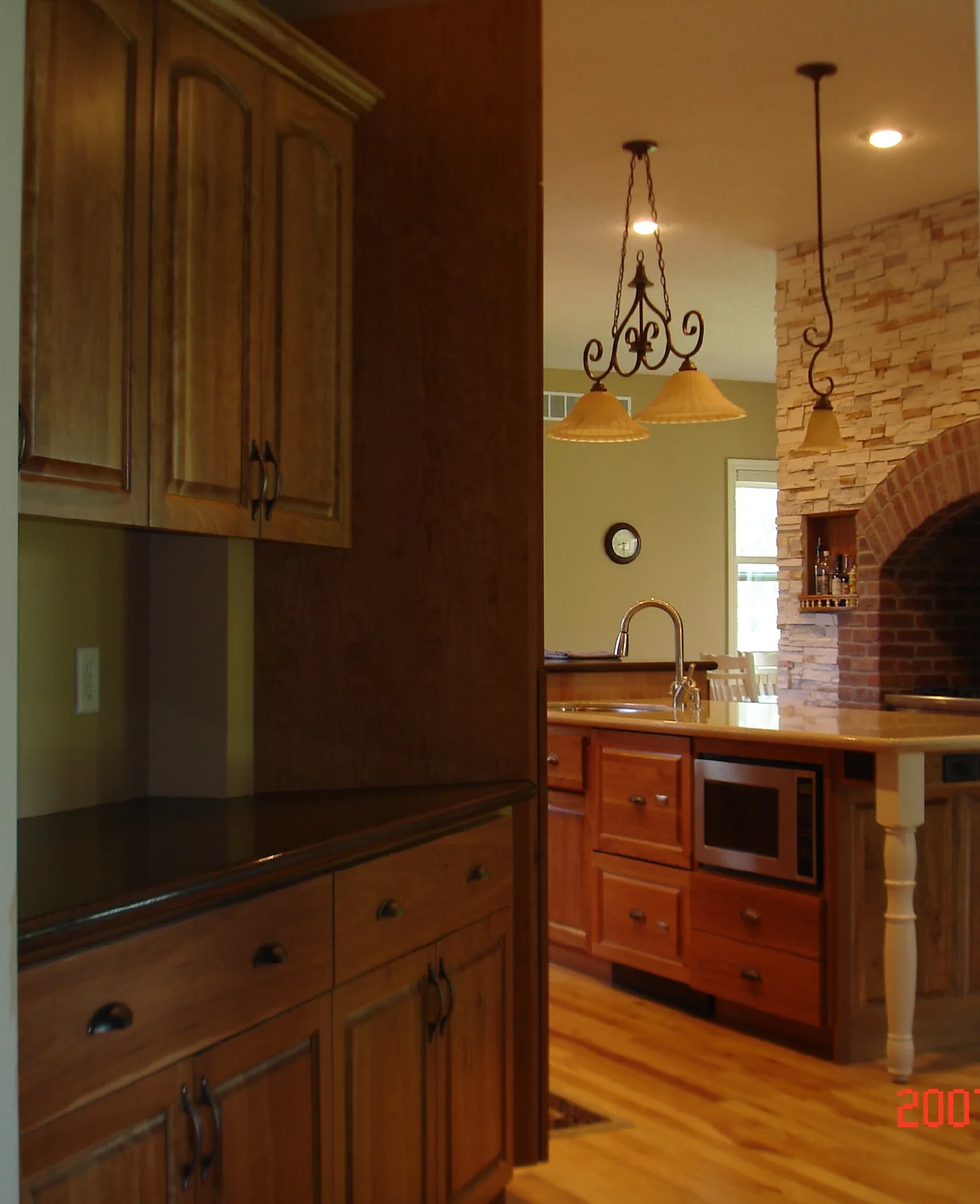 Custom cherry kitchen cabinetry with glass display uppers