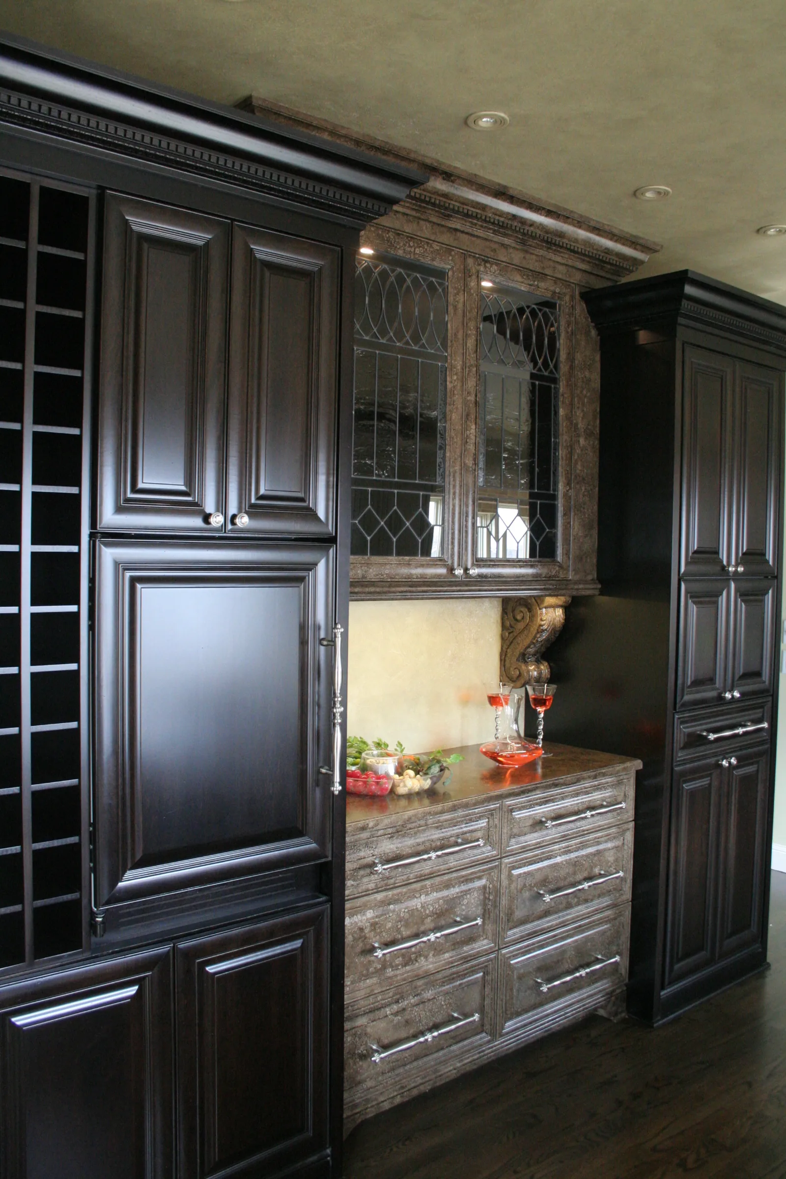 Built-in espresso wine and bar cabinetry with leaded glass doors