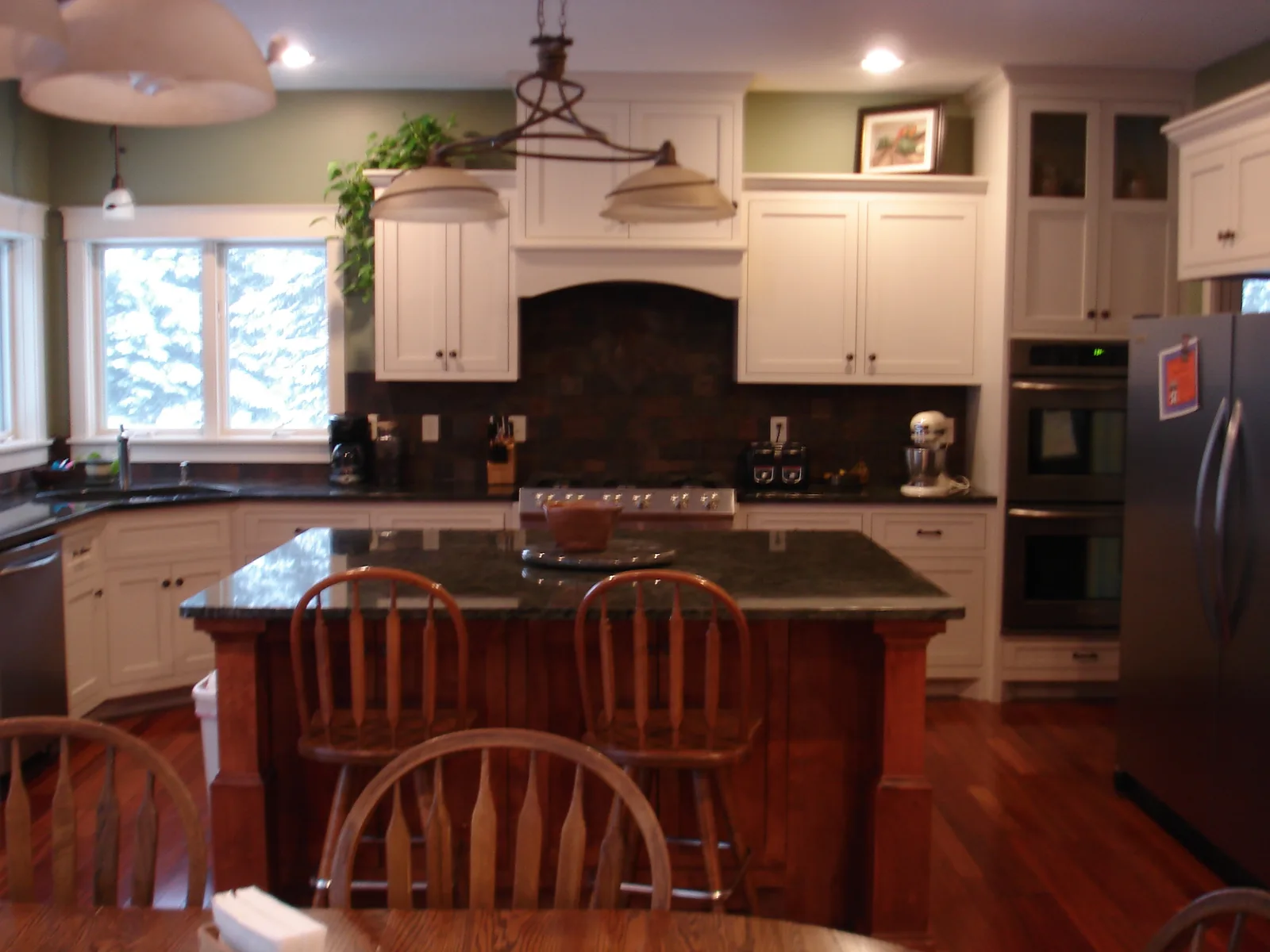 White custom kitchen cabinetry with tile backsplash and center island, built by Kreuser Cabinets